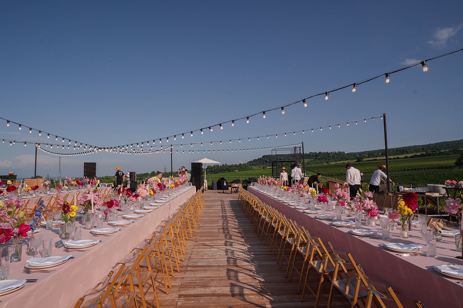 Evening banquet table set with flowers and lights overlooking the Tsinandali vineyards at dusk