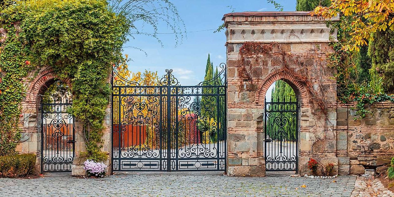 Wrought-iron entrance gates of Tsinandali Estate framed by autumn foliage
